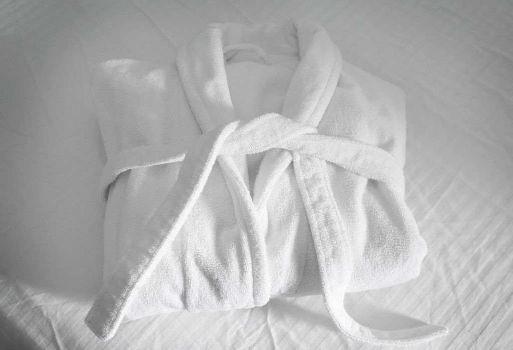 Folded spa bathrobe on bed